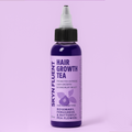 Skyn Fluent Hair Growth Tea purple bottle on a pastel background, labeled with rosemary, fenugreek, and butterfly pea flowers for extreme growth and dandruff relief